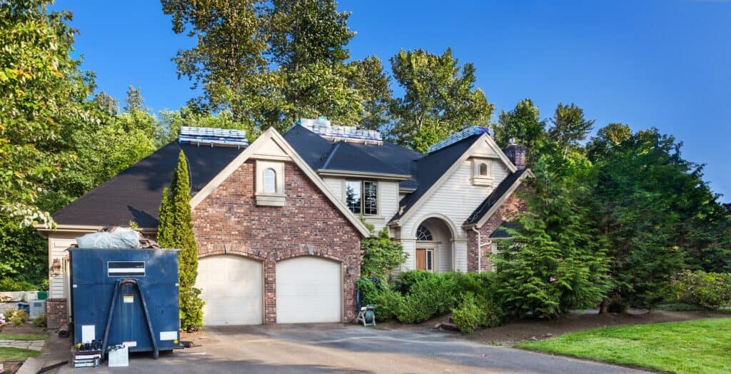 home with bags of roofing tiles getting ready for a roof replacement