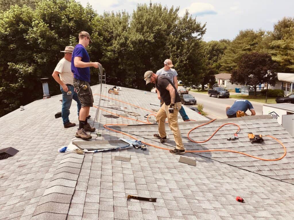 contractors re-roofing a residential home with shingles