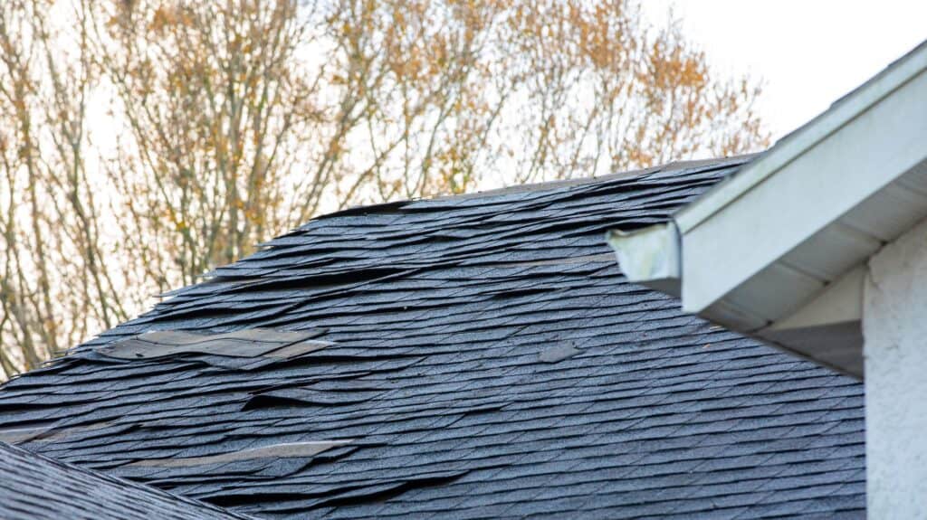 Damaged asphalt shingles on a residential roof