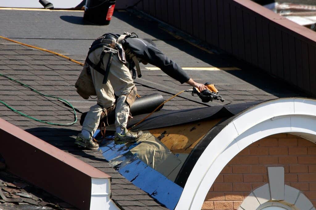 roofer doing a roof replacement nailing shingles to the roof