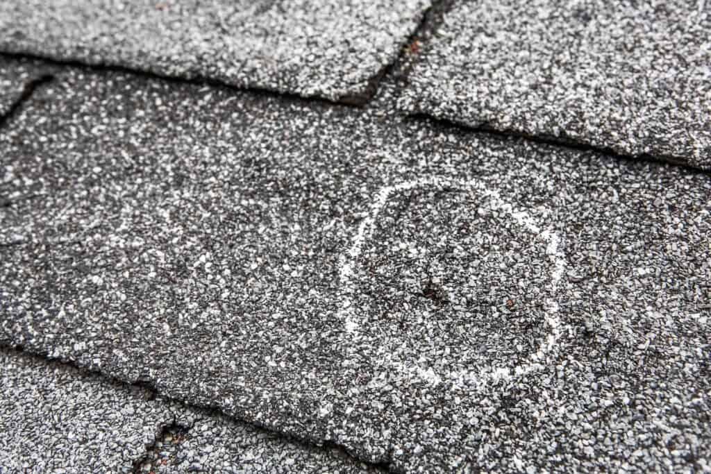 close up of hail damage on roof circled with chalk