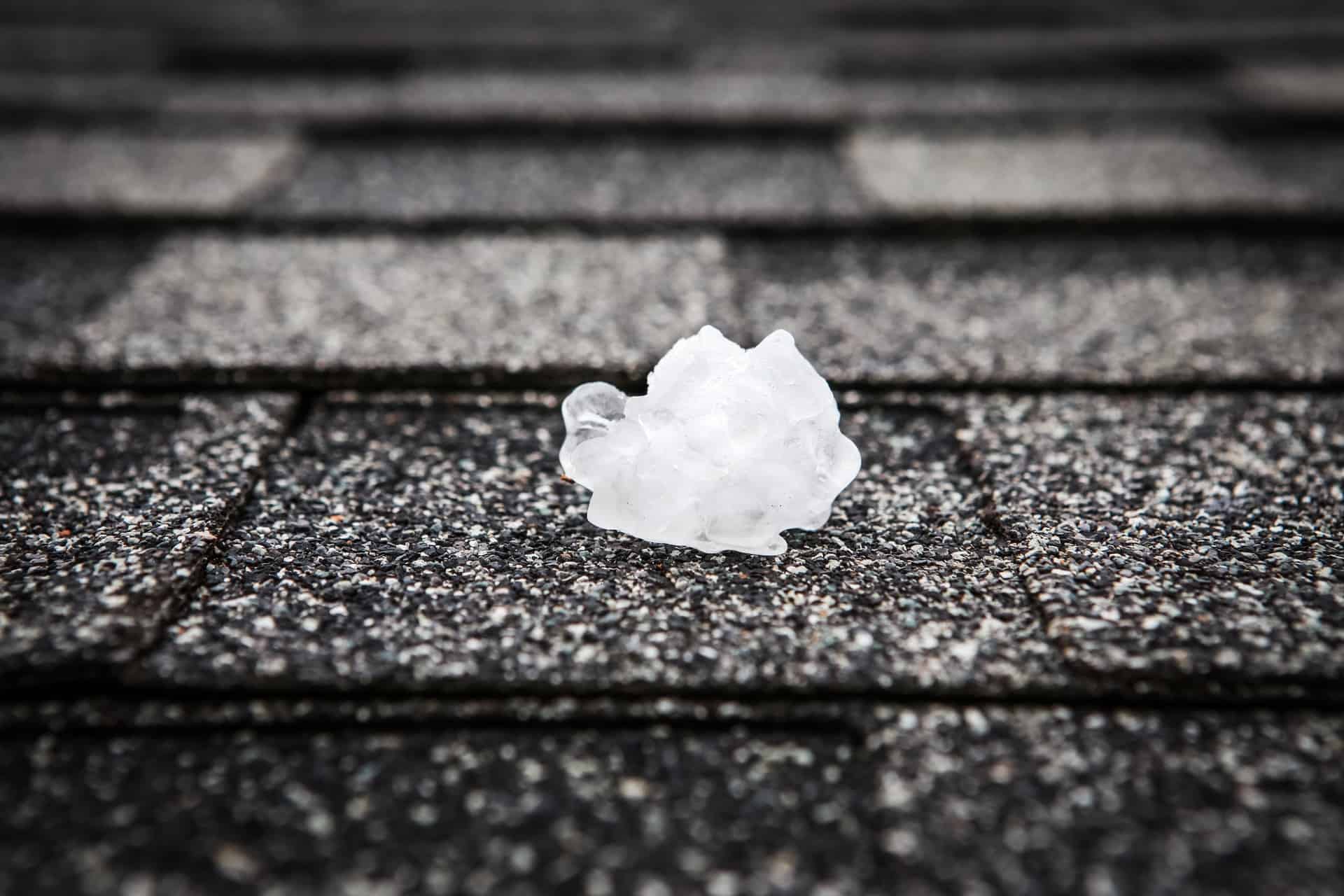 hail stone sitting on shingle roof